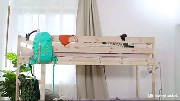 Big-Titted Brunette Guides Her Roommate’s Mouth Down Her Body on the Hostel Bed